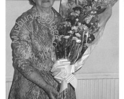 Image of Hilda Tryphena Turl holding a bouquet of flowers.